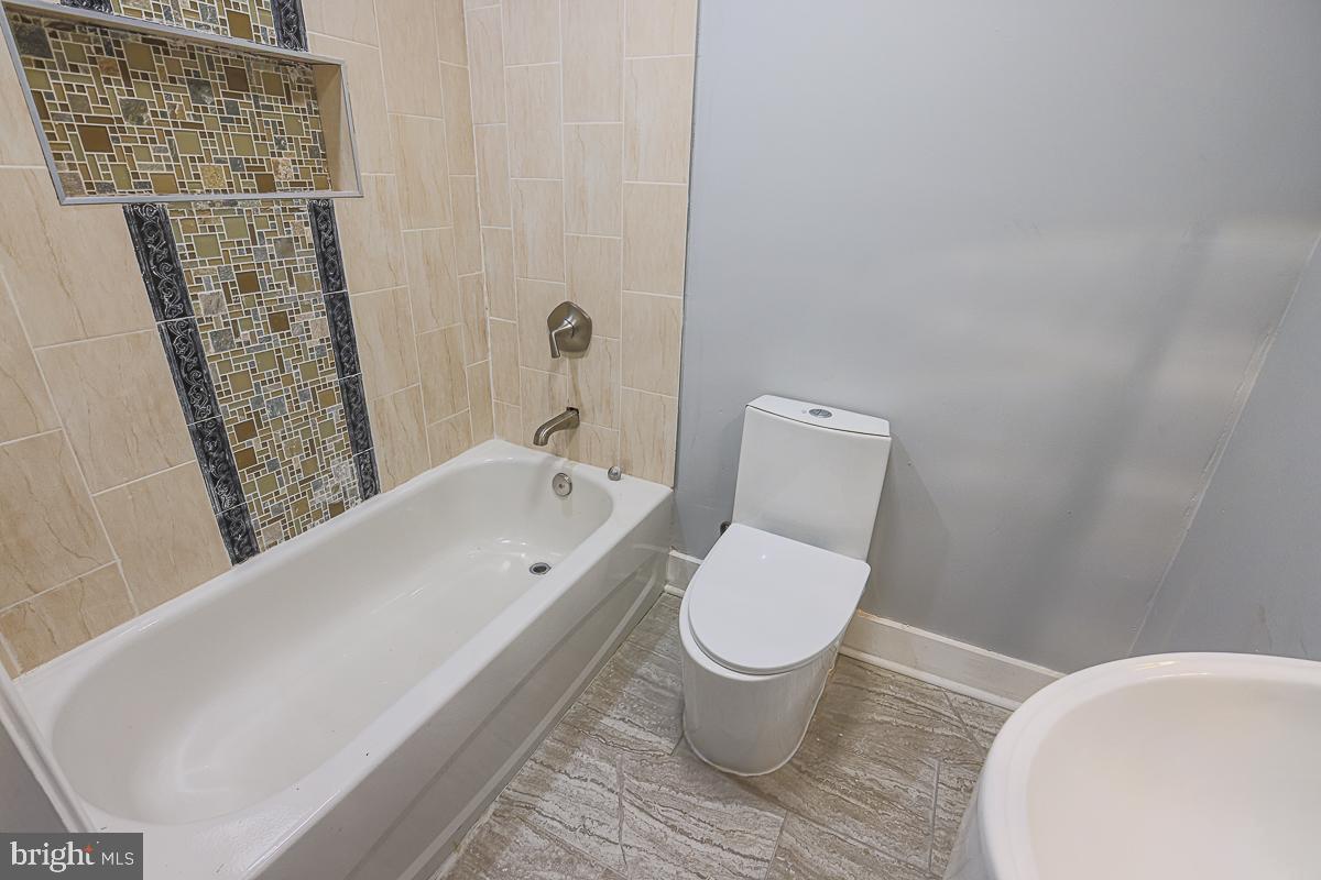 604 East 31st Street Baltimore, MD 21218 - Photo 39 of 50 a bathroom with a toilet and a bathtub