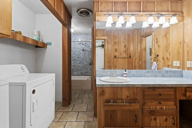 a bathroom with a granite countertop sink a mirror and a shower