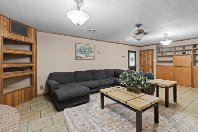 a living room with furniture a chandelier and kitchen view
