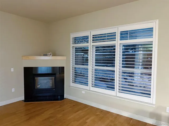 a view of an empty room with a fireplace and window