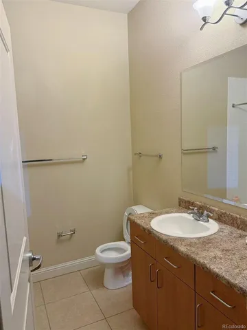a bathroom with a granite countertop toilet a sink and a mirror