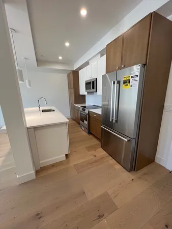 a kitchen with stainless steel appliances a refrigerator sink and microwave