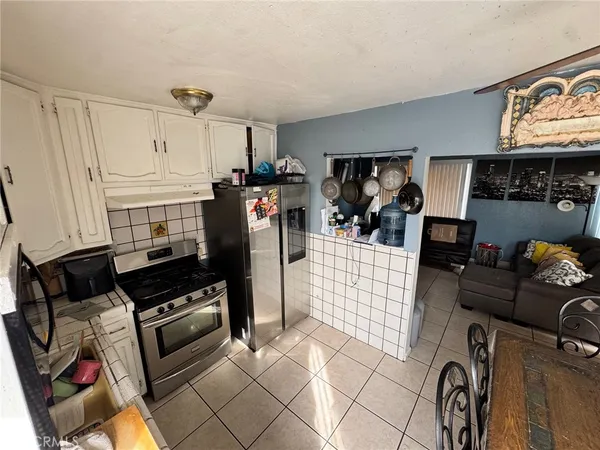 a kitchen with stainless steel appliances kitchen island granite countertop a refrigerator and stove