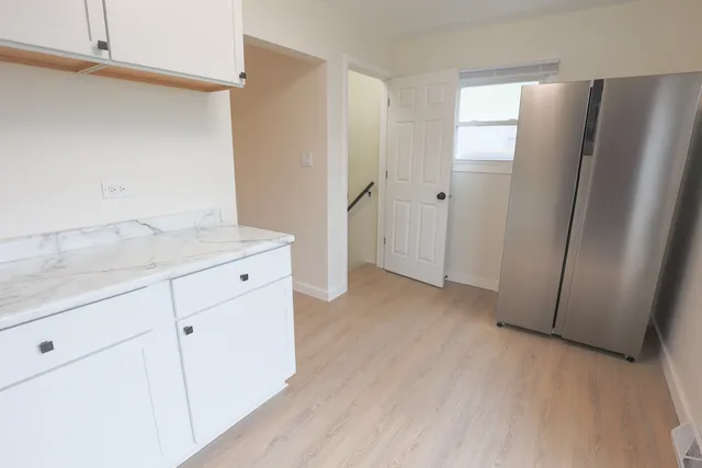 a view of a kitchen with refrigerator and cabinet