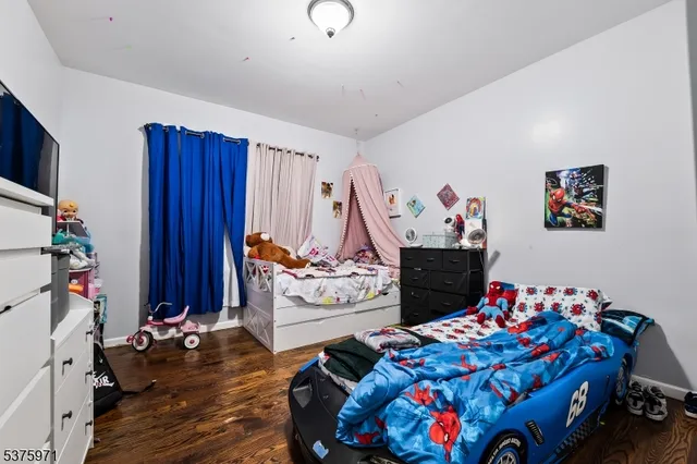 a bedroom with bed and a wooden floor