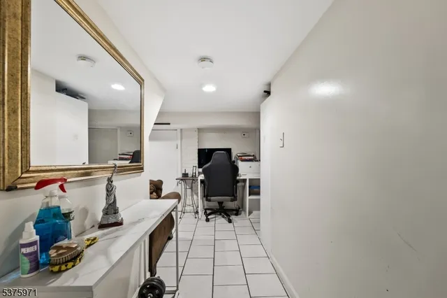 a view of a hallway with workspace and mirror