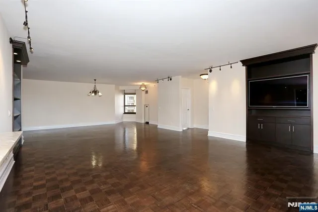 a view of empty room with wooden floor