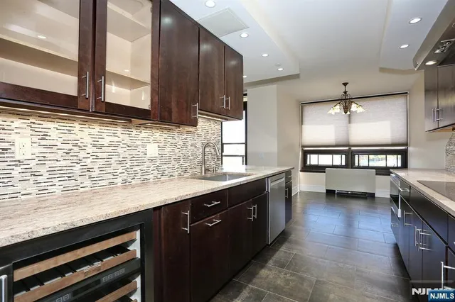 a kitchen with stainless steel appliances kitchen island granite countertop a sink and cabinets