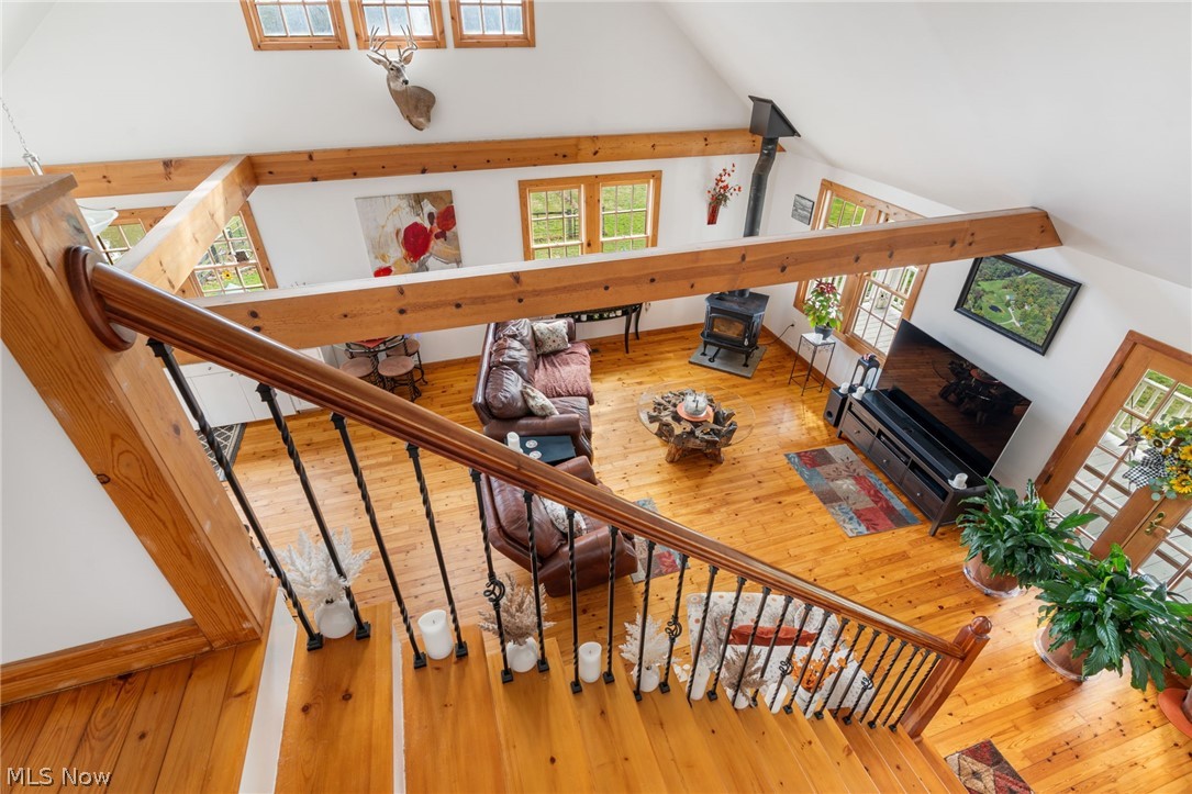 2210 Scroll Road Southwest Carrollton, OH 44615 - Photo 18 of 48 Stairs featuring hardwood / wood-style floors, a wood stove, and a high ceiling