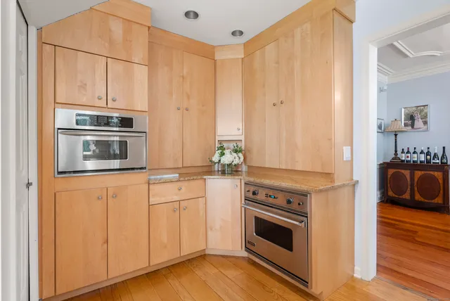 a kitchen with granite countertop white cabinets and stainless steel appliances