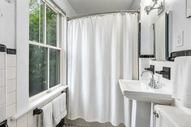 a bathroom with a sink a mirror and a window