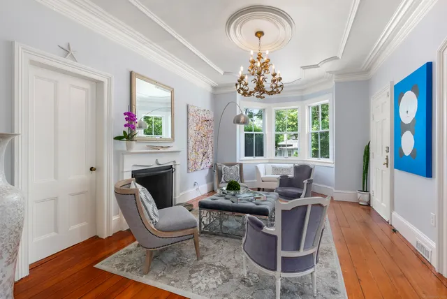 a living room with furniture chandelier and a fireplace