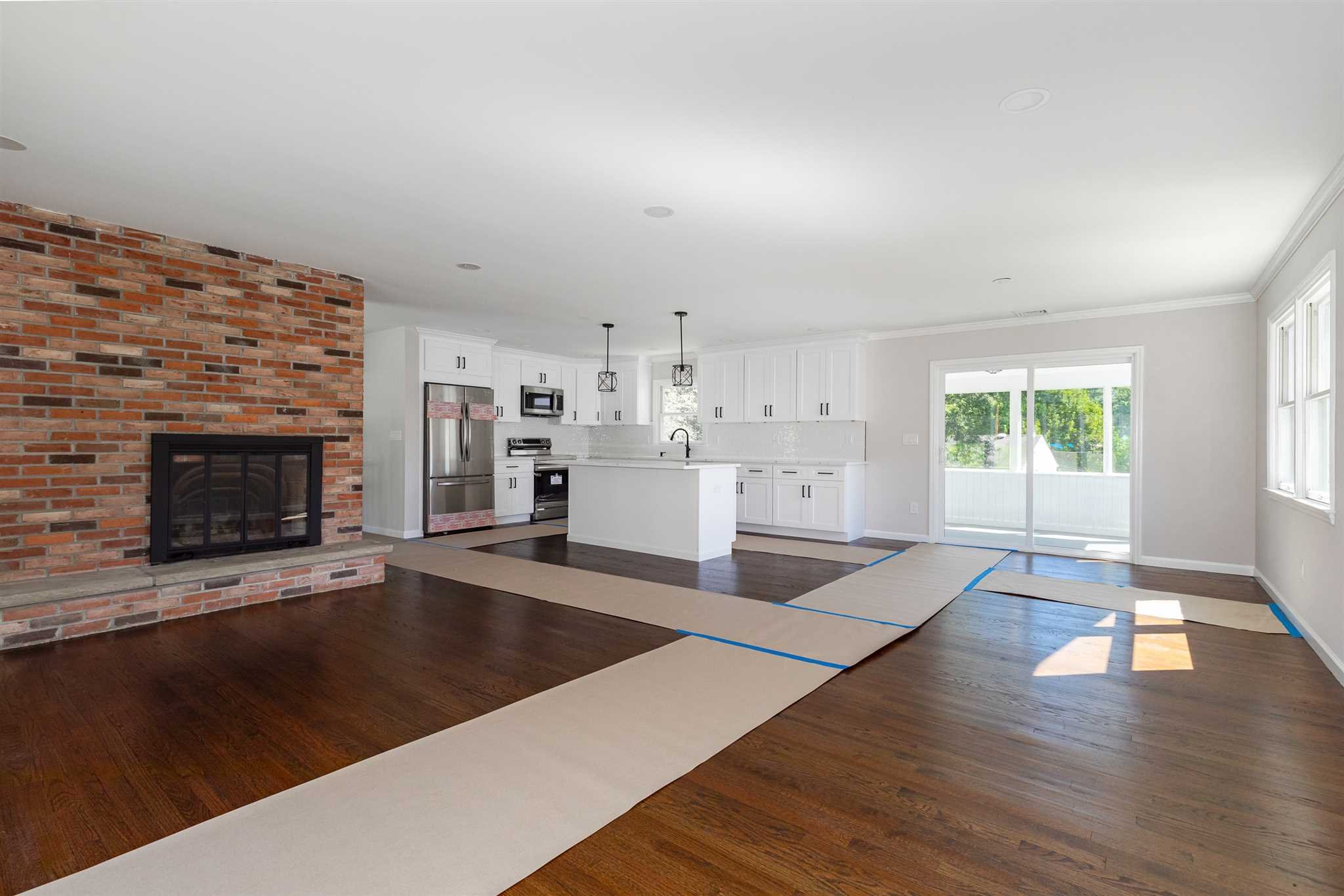 9 Manor Way Poughkeepsie, NY 12603 - Photo 3 of 23 a large living room with stainless steel appliances kitchen island a fireplace wooden floor and a window