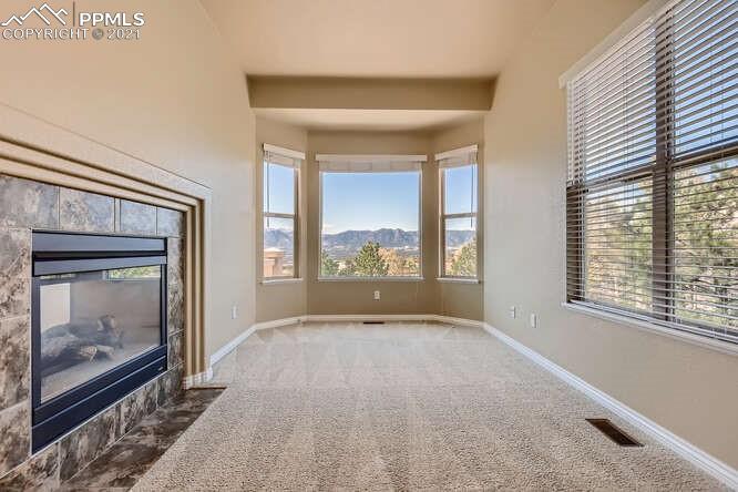13968 Windy Oaks Road Colorado Springs, CO 80921 - Photo 16 of 34 a view of an empty room with a fireplace and a window