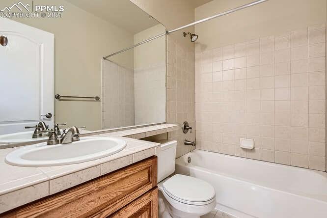 13968 Windy Oaks Road Colorado Springs, CO 80921 - Photo 25 of 34 a bathroom with a sink a toilet a mirror a bathtub and shower
