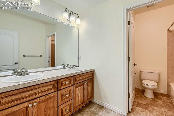 13968 Windy Oaks Road Colorado Springs, CO 80921 - Photo 27 of 34 a bathroom with a sink a toilet and a mirror