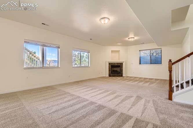13968 Windy Oaks Road Colorado Springs, CO 80921 - Photo 28 of 34 a view of an empty room with a fireplace and a window