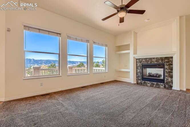 13968 Windy Oaks Road Colorado Springs, CO 80921 - Photo 9 of 34 a view of an empty room with a window and a fireplace