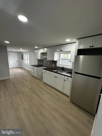 a kitchen with granite countertop a refrigerator and a sink