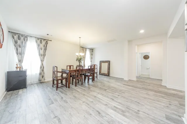 a view of a a dining room with furniture window and wooden floor