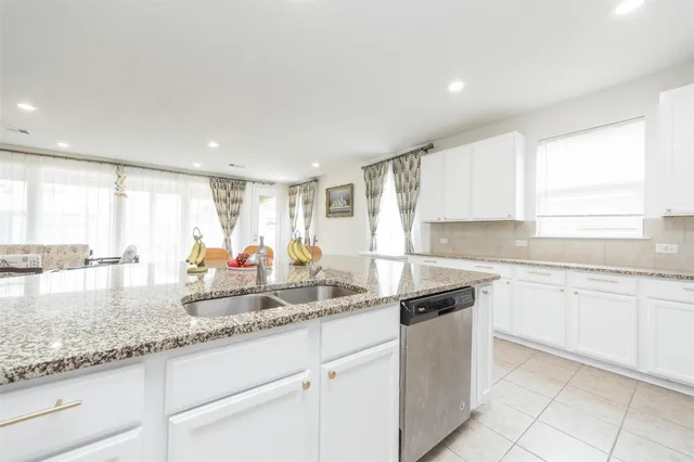 a kitchen with granite countertop a sink white cabinets and a granite counter tops