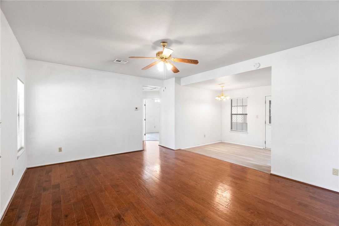 9616 Pvt Huisache Ranch Sinton, TX 78387 - Photo 21 of 21 an empty room with wooden floor chandelier fan and windows