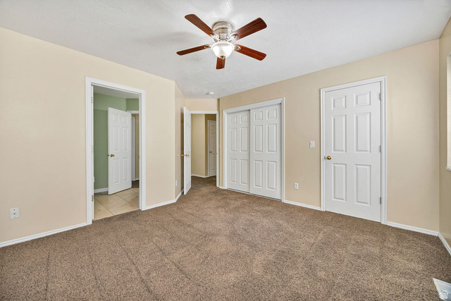 2 West 1780 North Logan, UT 84341 - Photo 18 of 24 Unfurnished bedroom featuring carpet flooring, ceiling fan, and a closet