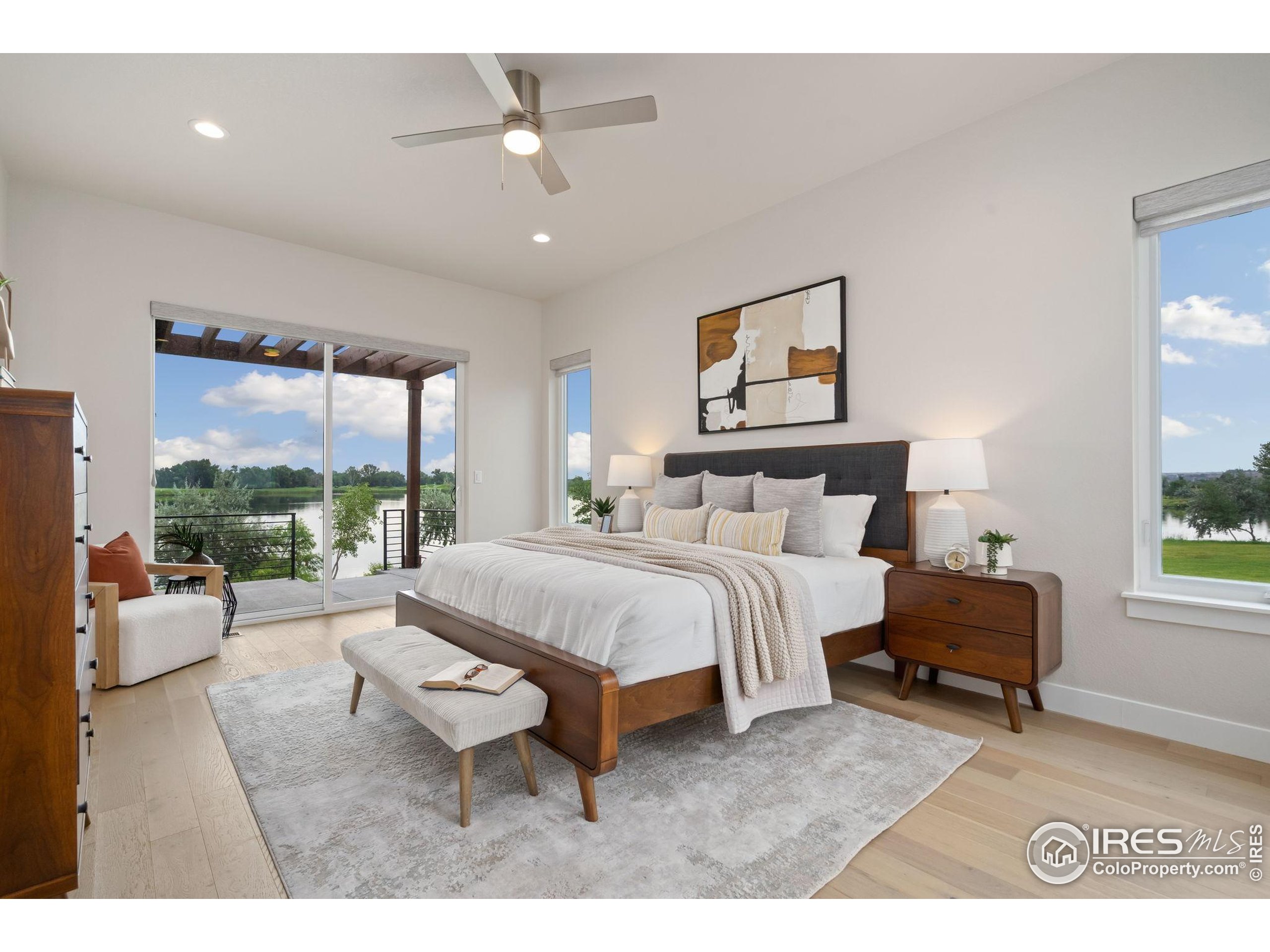 1729 Beachside Drive Windsor, CO 80550 - Photo 19 of 49 a spacious bedroom with a bed a couch and large window