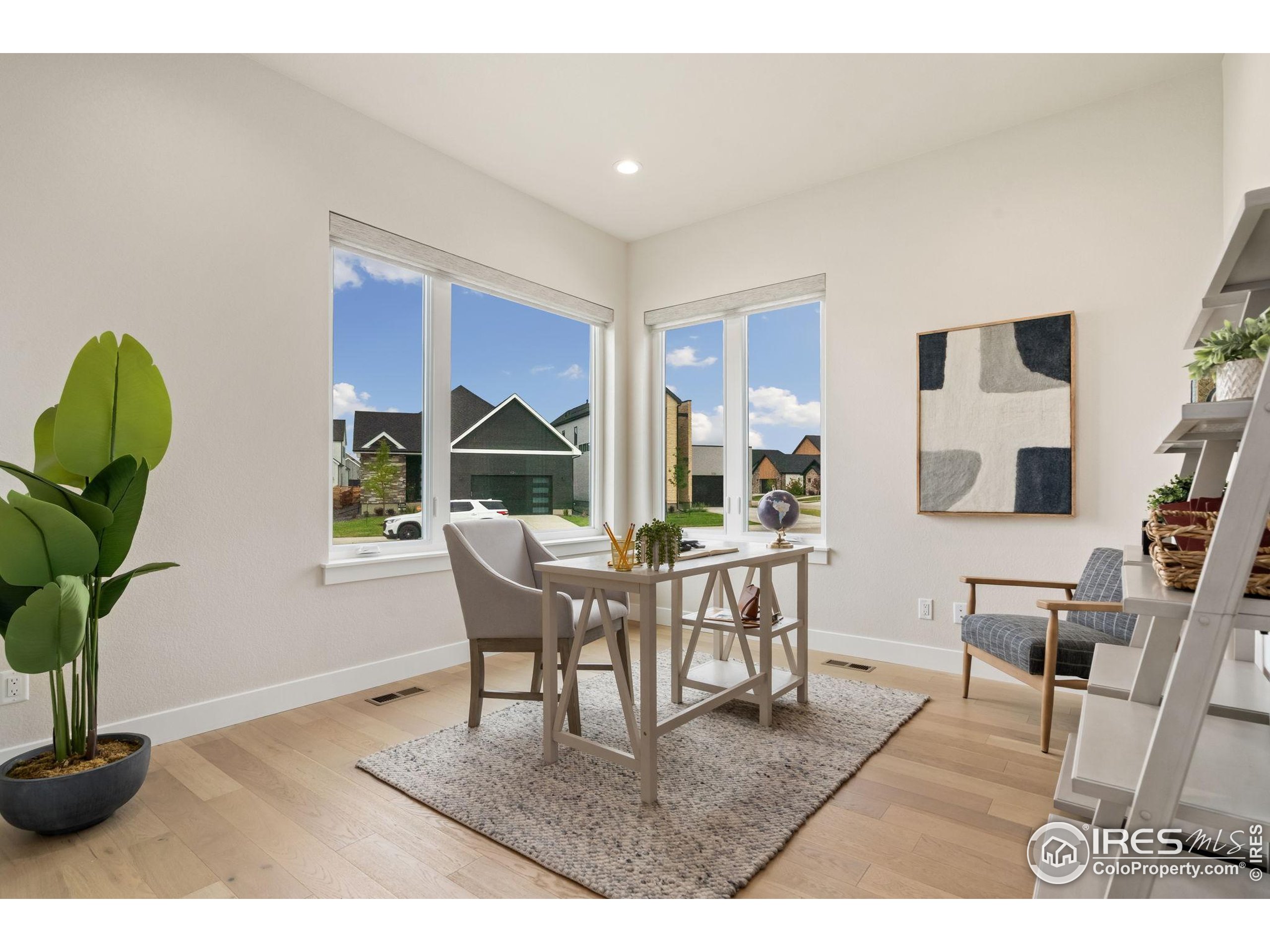 1729 Beachside Drive Windsor, CO 80550 - Photo 25 of 49 a dining room with furniture potted plants and wooden floor