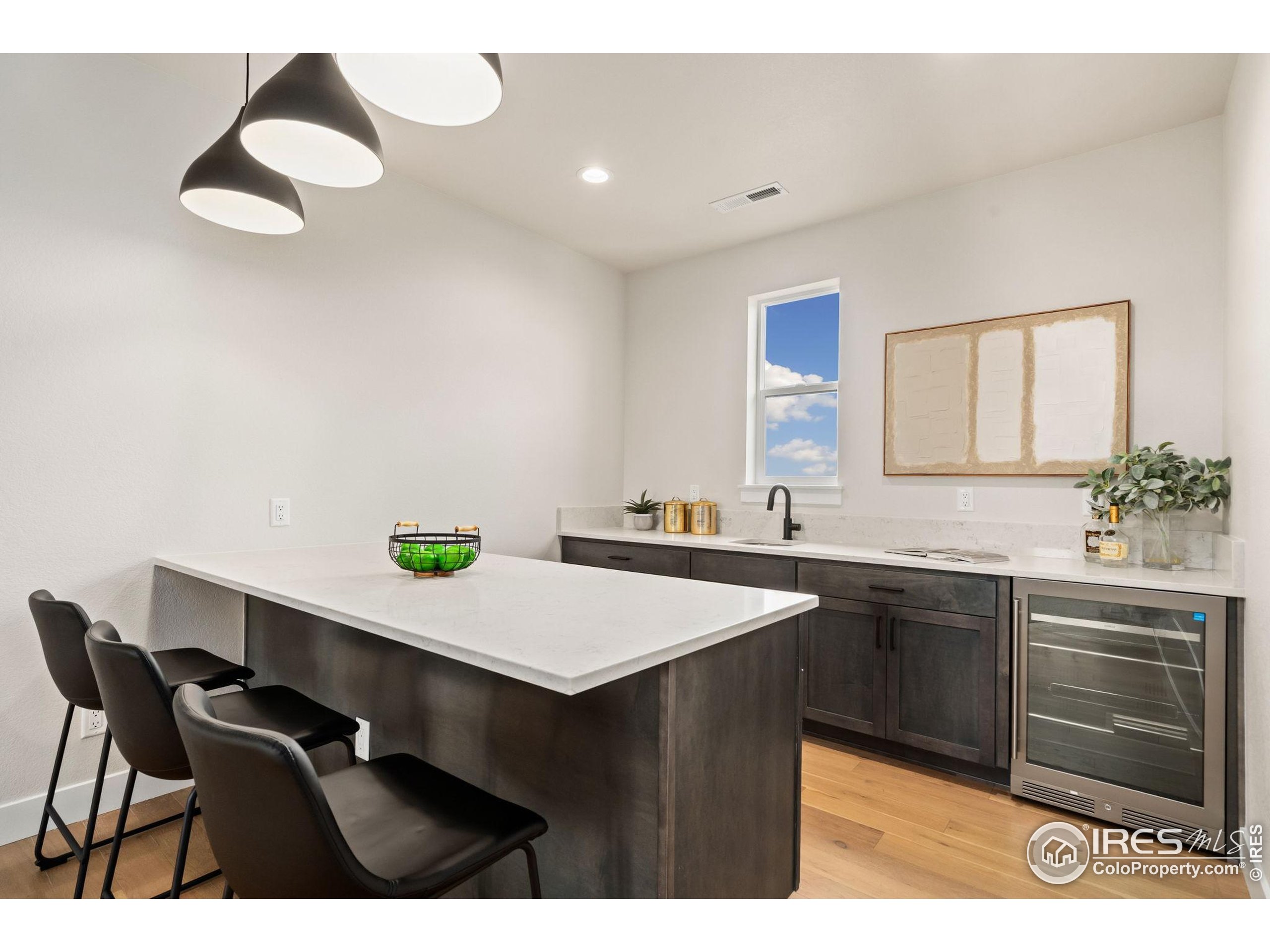 1729 Beachside Drive Windsor, CO 80550 - Photo 30 of 49 a kitchen with a sink cabinets and wooden floor
