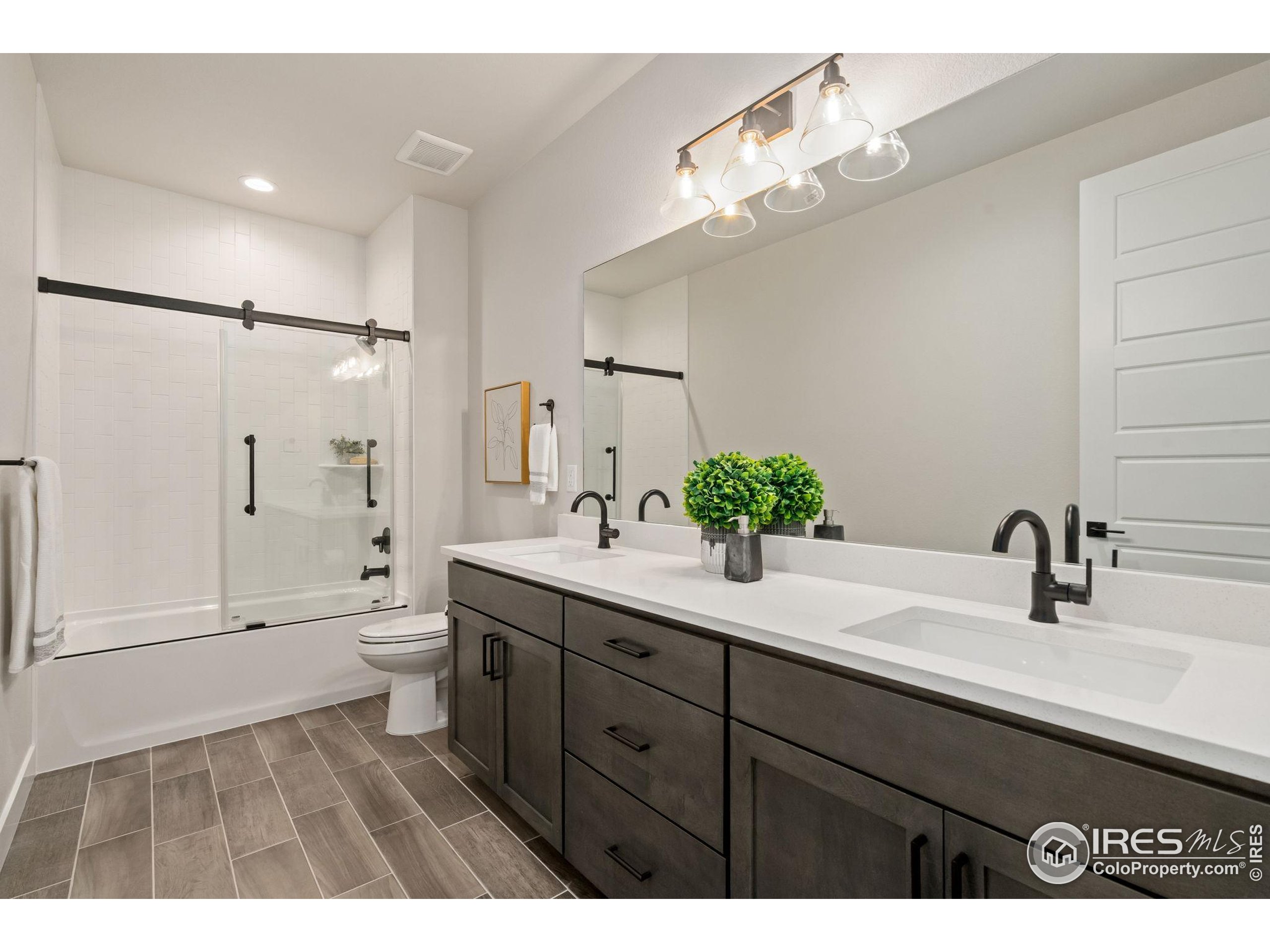 1729 Beachside Drive Windsor, CO 80550 - Photo 39 of 49 a bathroom with a sink a toilet and a large mirror