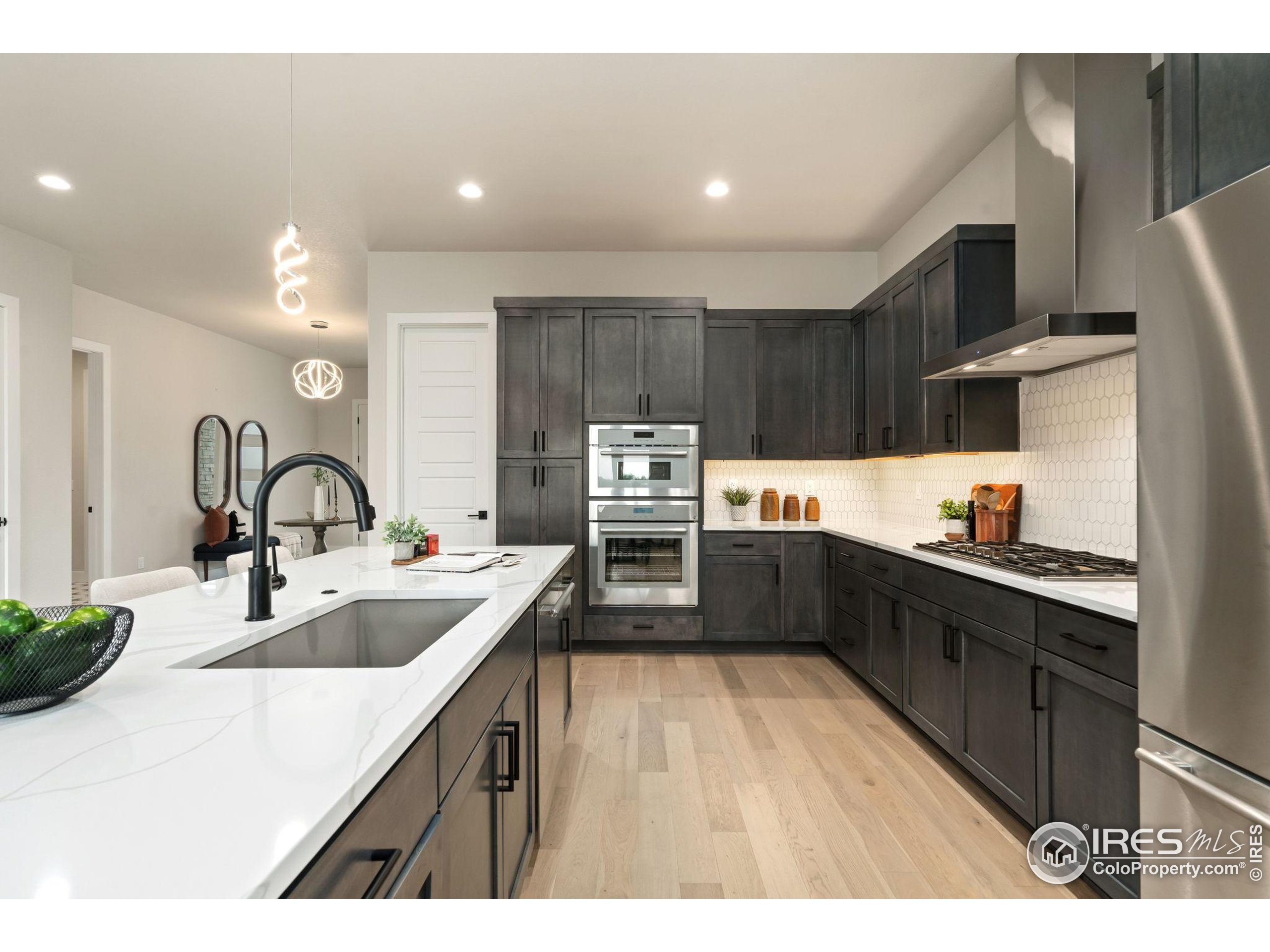 1729 Beachside Drive Windsor, CO 80550 - Photo 8 of 49 a kitchen with granite countertop a sink stove and refrigerator