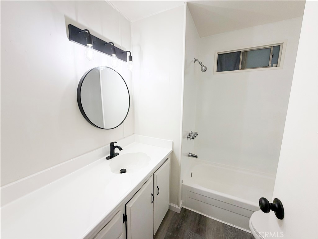 104 Sir Tristram Drive, Unit 104 Riverside, CA 92507 - Photo 24 of 26 a bathroom with a sink a toilet and a mirror