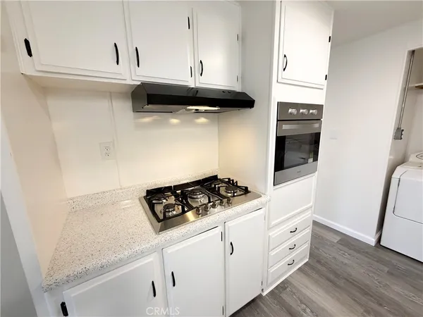 a kitchen with granite countertop a sink cabinets and stainless steel appliances
