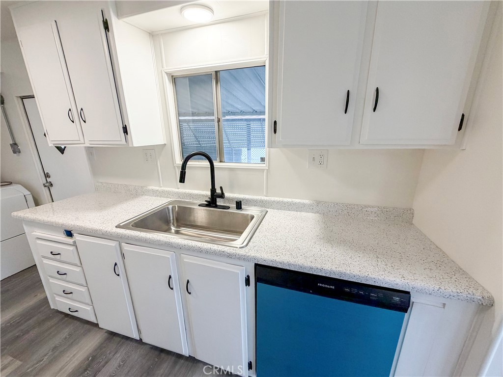 104 Sir Tristram Drive, Unit 104 Riverside, CA 92507 - Photo 5 of 26 a kitchen with a sink cabinets and wooden floor