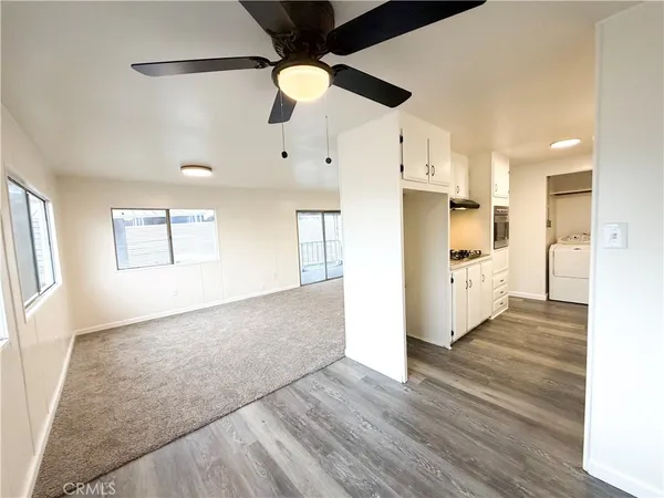 a view of a kitchen with wooden floor a sink and windows