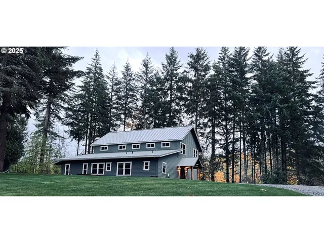 a view of a big house with a big yard and large trees