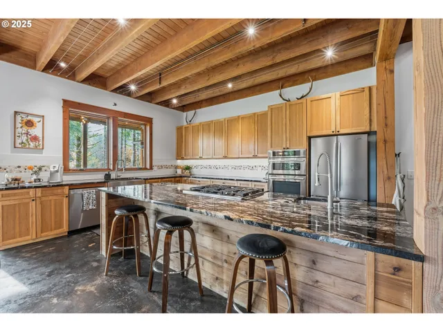 a kitchen with stainless steel appliances granite countertop a stove a sink dishwasher and a refrigerator