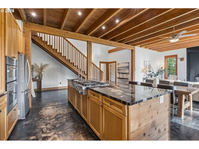a kitchen with stainless steel appliances granite countertop a sink and a refrigerator