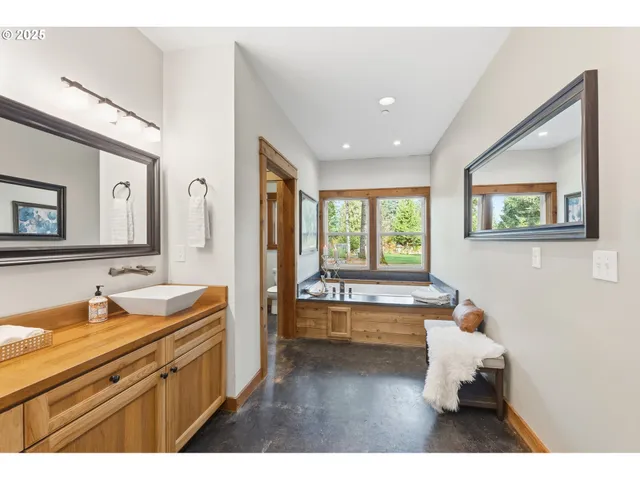 a bathroom with a bathtub sink and view of living room