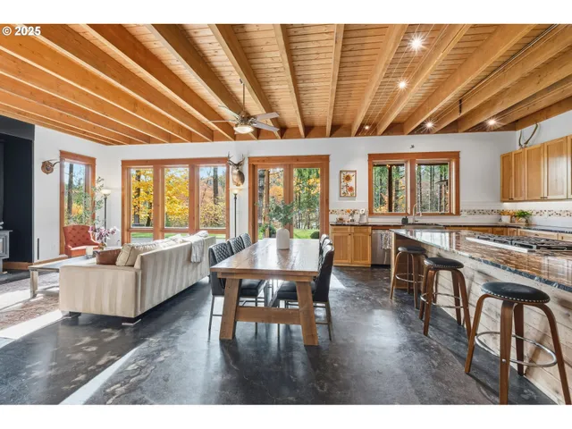 a living room with furniture wooden floor and large windows