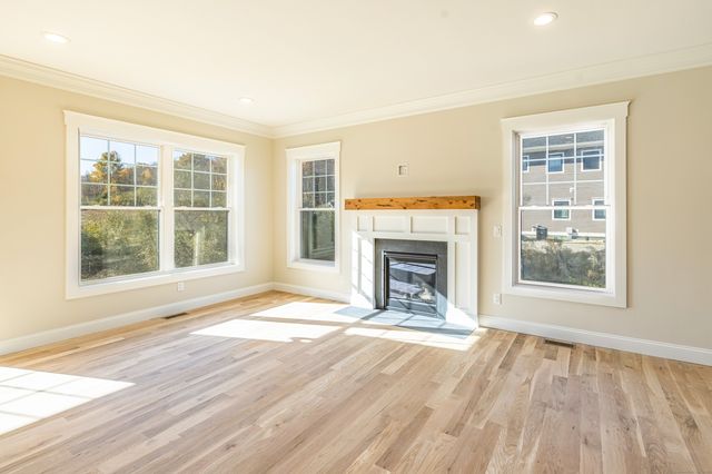 a view of empty room with wooden floor and fireplace
