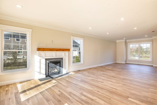 a view of an empty room with a window and fireplace