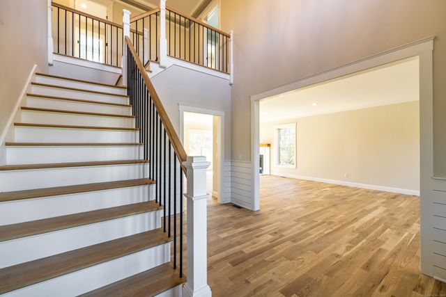 a view of a hallway with wooden floor and door