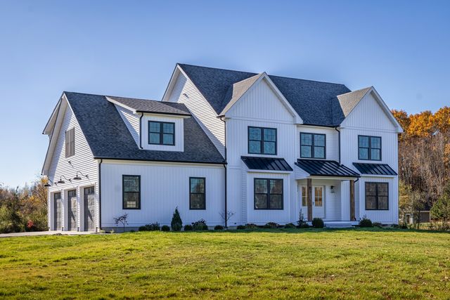 a view of a big house with a big yard and large trees