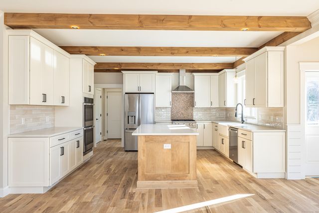 a large kitchen with kitchen island a stove a sink dishwasher and a refrigerator