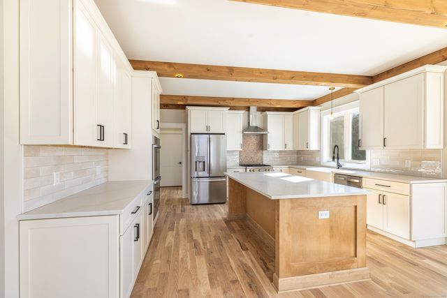 a kitchen with a stove a sink and a refrigerator