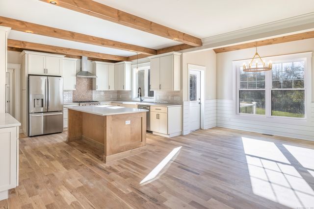 a large kitchen with a window and stainless steel appliances