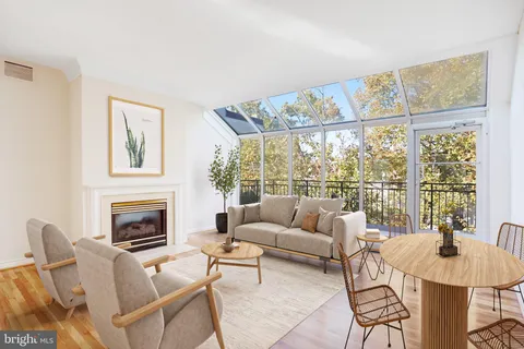 a living room with furniture a fireplace and a large window