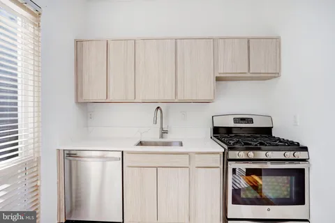 a kitchen with white cabinets and a stove with a sink